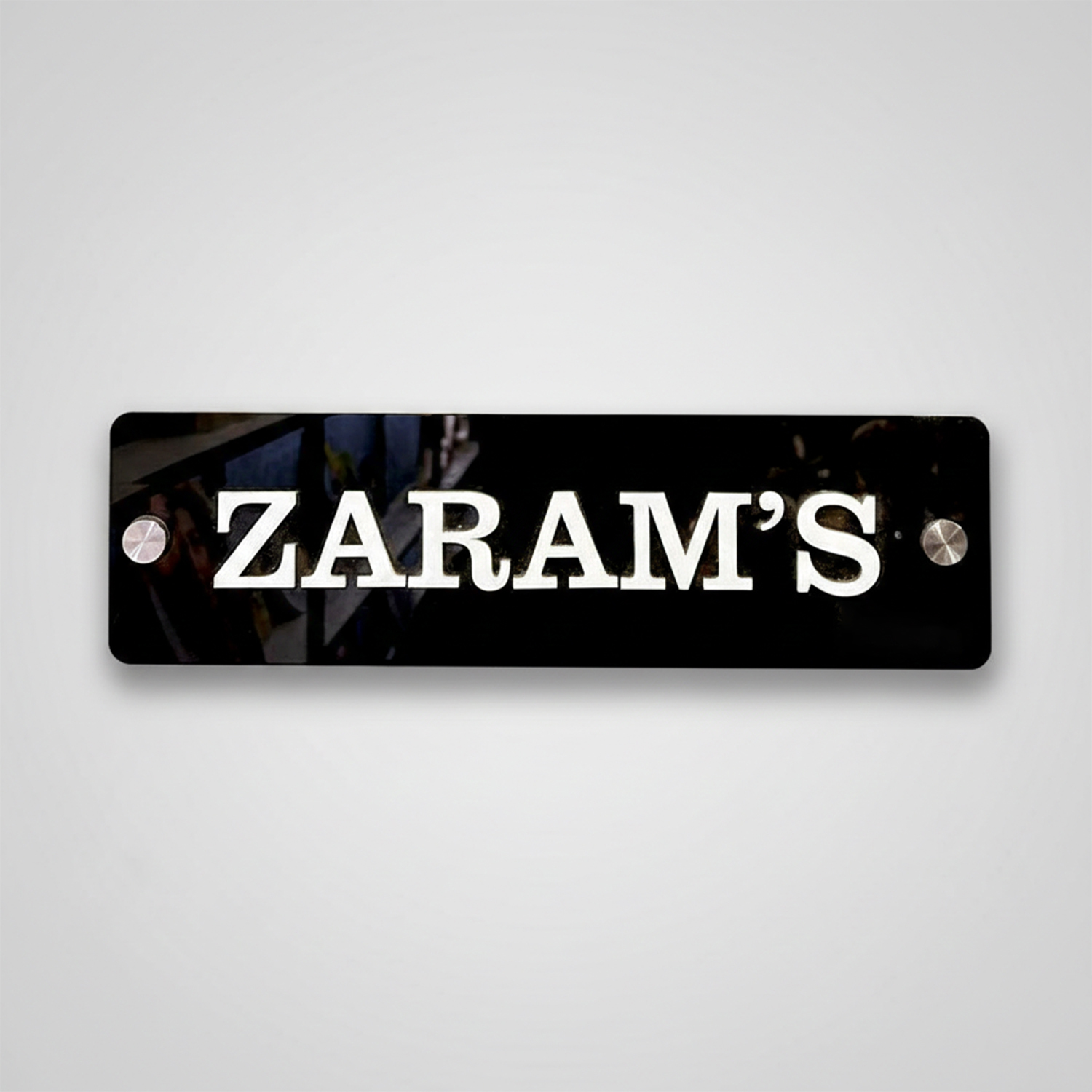 Modern minimal house nameplate with a black finish and sleek, white text.